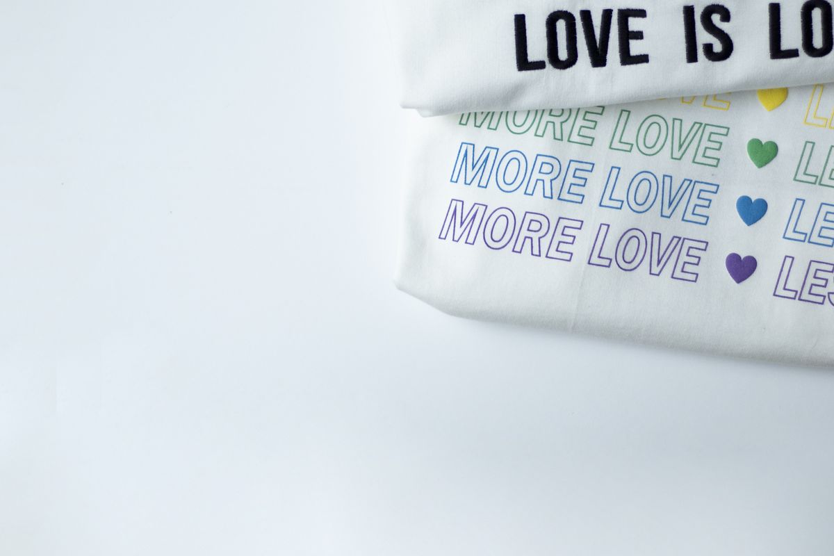 A folded white crew-neck t-shirt on a plain surface