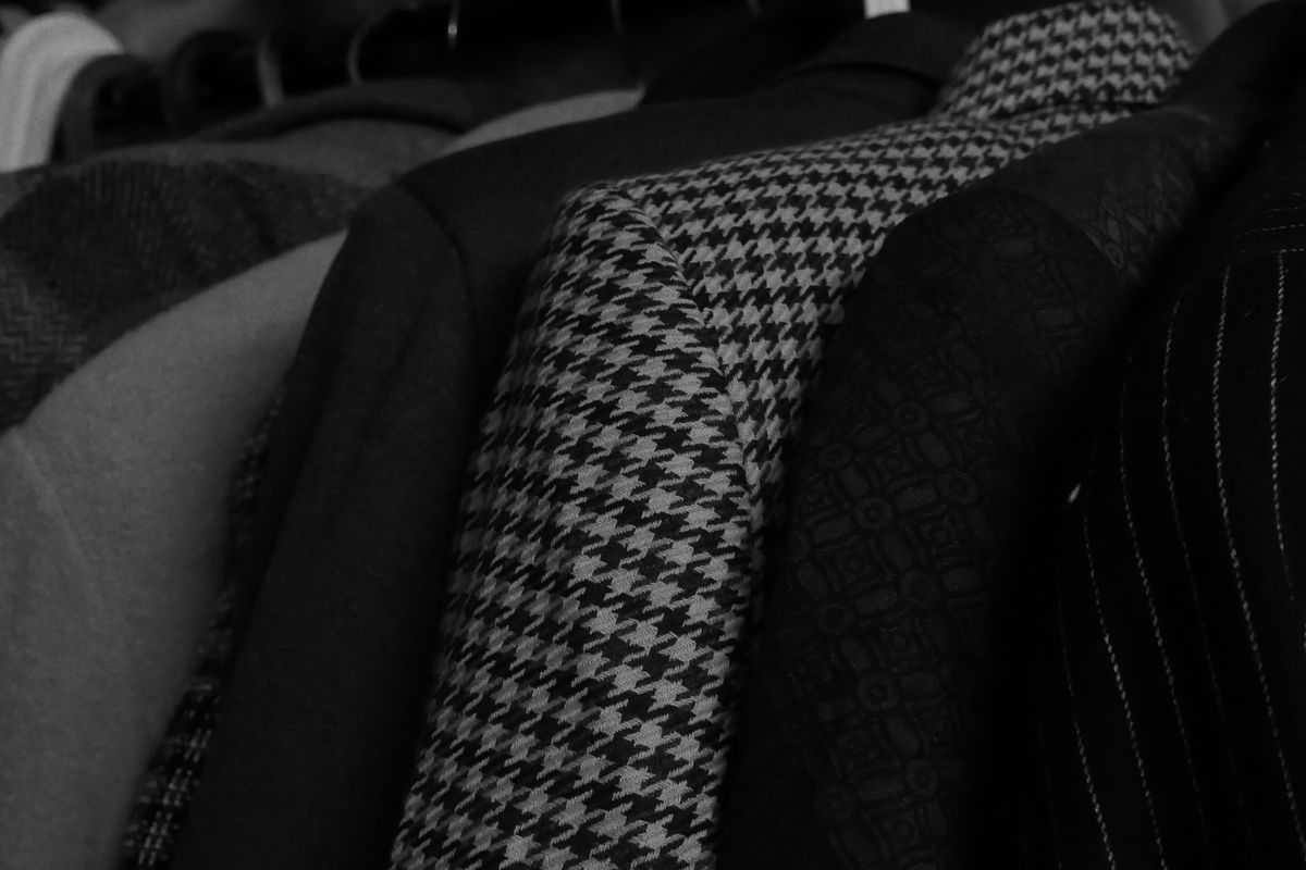 A small rack of hanging shirts and trousers