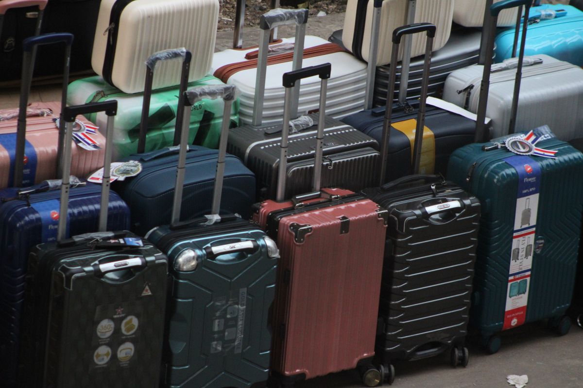 A hard-shell carry-on suitcase placed inside an airport baggage size gauge