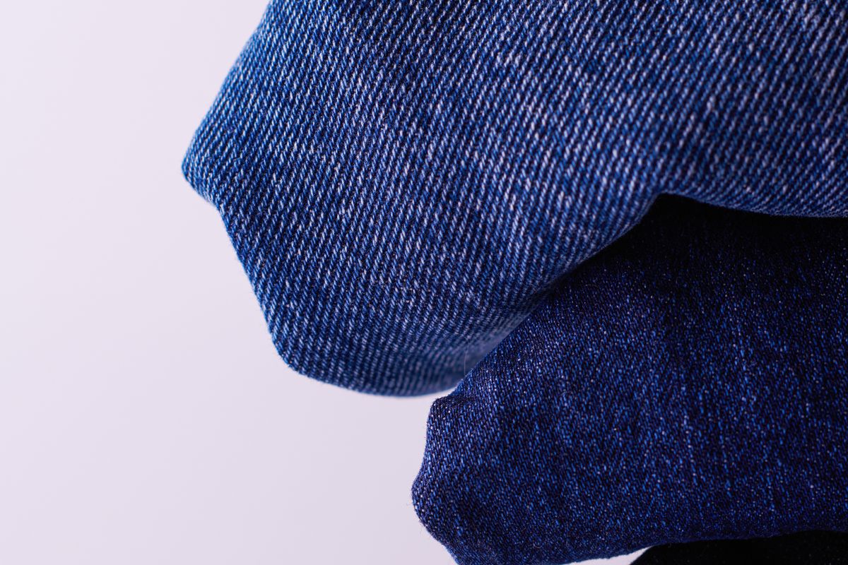 A folded stack of indigo denim showing the weave close up