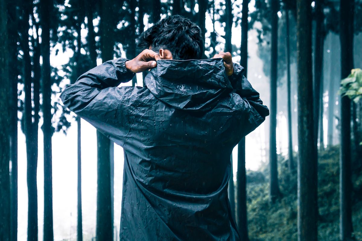 A waterproof shell jacket hanging against a wet background
