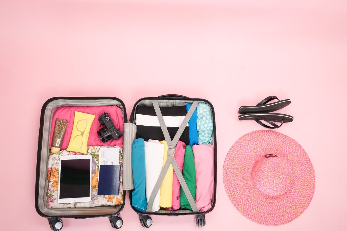 An open suitcase packed with folded clothes