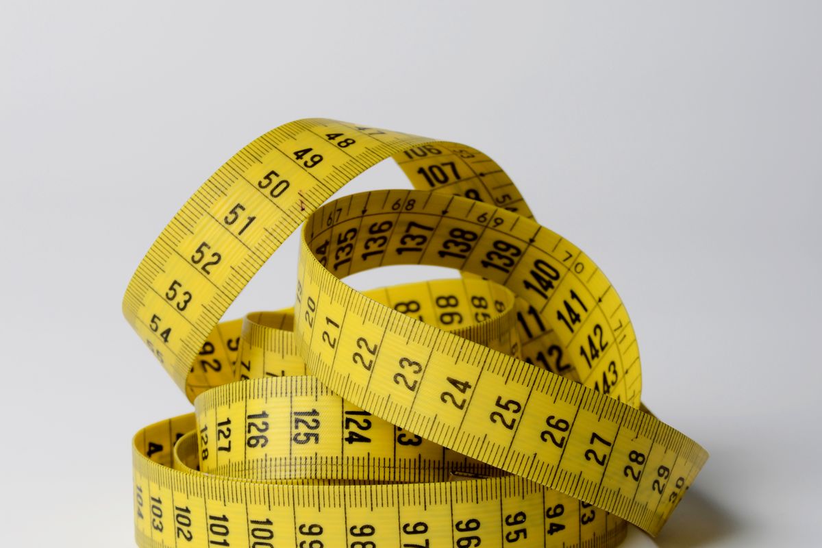 A tape measure laid across a folded stack of clothing