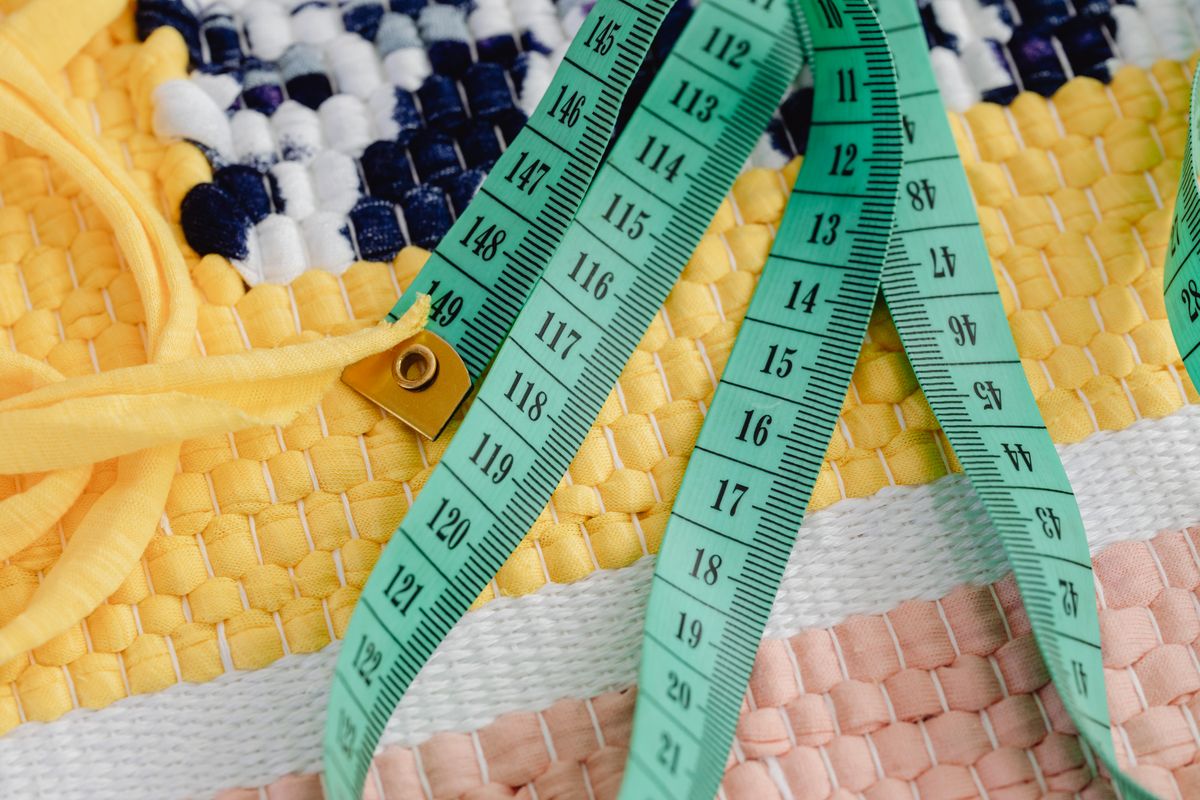 A shirt laid flat with a tape measure showing space between the garment and the body outline